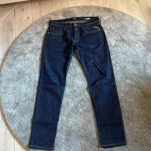 Replay Anbass jeans mörkblå, stl Waist32 och Length 30 - Säljer ett par snygga Replay Anbass jeans i mörkblå tvätt. Klassisk femficksmodell med raka ben och kontrastsömmar. Jeansen har en stilren look och passar perfekt till sneakers eller boots. Materialet är slitstarkt denim i bomull.  Använd få tal gånger som nya 9/10 skick