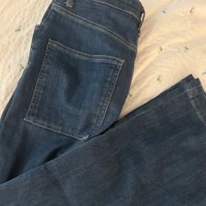Mörkblå wide jeans med raka ben - Säljer ett par mörkblå jeans med bred passform och raka ben. Jeansen har klassiska fickor både fram och bak, samt hällor för bälte. Materialet är mjukt denim och modellen sitter snyggt i midjan. Perfekta för en chill och trendig look.