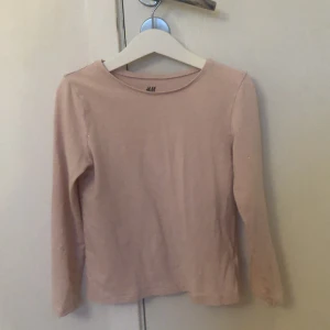 Ljusrosa långärmad tröja H&M - En basic ljusrosa långärmad tröja från H&M i mjuk ekologisk bomull. Enkel och stilren modell med rund halsringning, perfekt att matcha med jeans eller kjol. Skön och lätt att bära till skolan eller häng med kompisar.