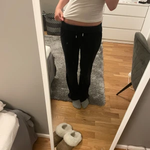 Mörkblåa Juicy Couture mjukisbyxor XXS - Svarta mjukisbyxor från Juicy Couture i supermjuk velour med broderad logga och snörning i midjan. Byxorna har låg midja, raka ben och fickor bak med knappar. Perfekta för en chill och trendig look. Jag är 158 och dom är lite långa.✨🫶🏻Ny pris 1200!!!