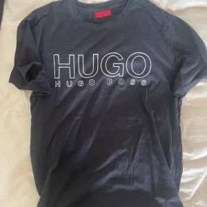 Hugo Boss T-shirt - Hugo Boss T-Shirt svart med silvertext i storlek M. 