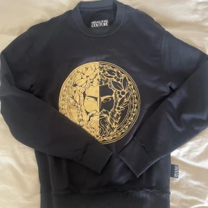 Versace College-tröja - Versace College-tröja. Svart med guld. Använd ett par gånger. Storlek XS. Köpt för 5000kr. 