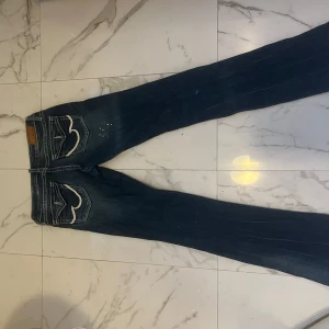 Mörkblå jeans från Amisu med brodyr - Snygga mörkblå jeans från Amisu med vita broderade detaljer på bakfickorna. Säljer då de är för små för mig. De är lågmidjade och bootcut.