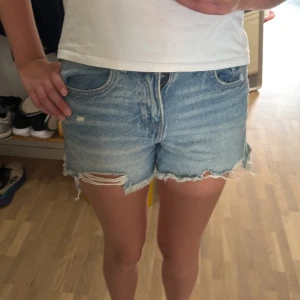 Blå jeansshorts från Zara - Säljer superfin kortbyxa från Zara pga att de tyvärr är lite för små!💕Medelhög midja! Midjemått: 34cm, gylf 10 cm, hela längden är typ 33cm! Pris kan diskuteras!