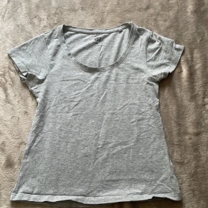 Grå basic t-shirt från lager 157 XS - Enkel grå t-shirt från 157 i storlek XS. T-shirten har rund halsringning och korta ärmar. Tillverkad i mjuk bomullsblandning som känns skön mot huden. Perfekt till jeans eller shorts för en clean look. 