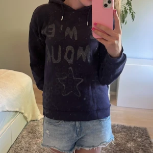 Mörkblå hoodie med glittertext Gina Tricot - Mörkblå hoodie från Gina Tricot med glittrig text och stjärna framtill. Tröjan har huva med snörning och långa ärmar. Perfekt för dig som gillar en chill och snygg stil. Mjuk insida och klassisk passform.