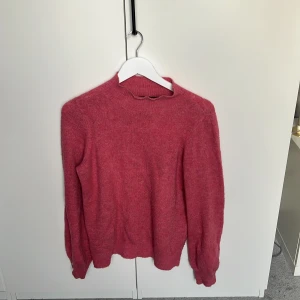 Rosa stickad tröja från Vero Moda - Mysig rosa stickad tröja från Vero Moda i storlek S. Tröjan har en enkel design med rund halsringning och långa ärmar. Perfekt för lager-på-lager och chill dagar. Materialet är mjukt och ger en skön känsla hela dagen.