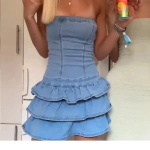 Ljusblå axelbandslös volangklänning - Supersöt kort klänning i ljusblå denim med tre lager volanger och helt oanvänd💞obs, inte mina bilder💓