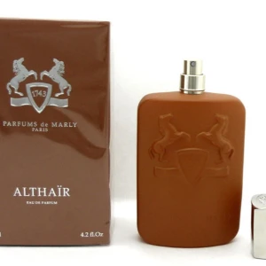 Parfums de Marly Althaïr EdP 75ml (70ml kvar) - Althaïr Eau de Parfum från Parfums de Marly i en snygg brun, matt flaska med silverdetaljer och reliefmönster av två hästar. Flaskan har en modern, fyrkantig form och känns lyxig och stilren. Perfekt för dig som gillar exklusiva dofter.