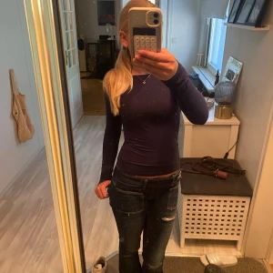 Mörkblå långärmad topp med öppen rygg - Säljer en mörkblå långärmad topp med tight passform och en riktigt snygg öppen rygg. Toppen är enkel framtill och har en djup urringning bak som gör den extra cool. Perfekt att styla med jeans eller kjol. Passar till alla årstider!🫰