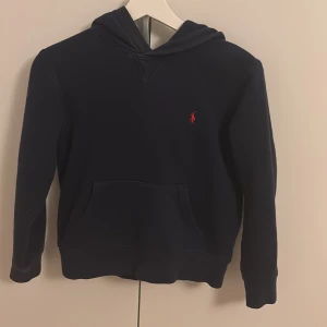 Mörkblå hoodie från Polo Ralph Lauren - Snygg mörkblå hoodie från Polo Ralph Lauren. Använd men fortfarande väldigt bra skick.