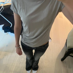 Beige kortärmad t-shirt  - Enkel och stilren beige t-shirt med korta ärmar och lätt rynkdetalj på ena sidan. 