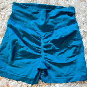 Blå seamless träningstights shorts - Snygga blå seamless shorts med hög midja och ribbad linning. Tight passform och scrunch-detalj bak för extra shaping. Perfekta för gymmet eller andra träningspass. Mjukt och stretchigt material som sitter skönt hela dagen.