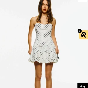 Vit prickig kortklänning Bershka - Supersöt vit kortklänning från Bershka med svarta prickar, tunna axelband och voluminös kjol. Helt ny lappen kvar o endast testad. Slutsåld på hemsidan❣️