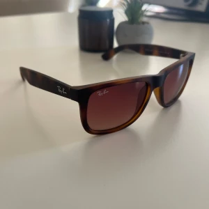 Ray-Ban Wayfarer brunmelerade solglasögon - Snygga Ray-Ban JUSTIN RB🤎Wayfarer solglasögon. matta bruna bågar och klassiskt gråa linser. Perfekta  för dig som vill ha en clean outfit. Original, använd 3-4 gånger. PRIS KAN DISKUTERAS🥰.————————————————-                                    ☀️ 100 % UV-skydd (UV400) – skyddar dina ögon från både UVA- och UVB-strålning. Perfekta för stranden😉  ✔️ Äkta Ray-Ban ✔️ Bra skick ✔️ Nypris ca 1400 kr  Säljer pga har för många solglasögon. Skickas snabbt & fint packat.