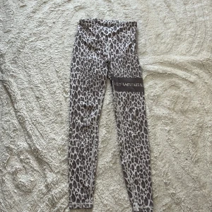 Leopardmönstrade leggings från Stronger - Snygga leopardmönstrade leggings från Stronger i beige och bruna toner. De är tillverkade i ett stretchigt material av återvunnen polyester och elastan, med hög midja och tight passform. Perfekta för träning eller chill dagar.