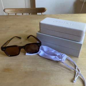 Bruna CHIMI solglasögon Tortoise - Snygga solglasögon från CHIMI i modellen Tortoise. De har en fyrkantig form och bruna glas med sköldpaddsmönstrade bågar. Kommer med originaletui och tygpåse. Perfekta för att lyfta din stil i sommar! Lätt utåtböjda men går att fixa lätt i någon glasögons butik!