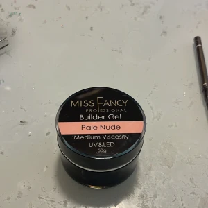 Miss Fancy Builder Gel Pale Nude - Builder Gel från Miss Fancy i färgen Pale Nude. Gelen har medium viskositet och passar för UV & LED-härdning. Kommer i en rund svart burk på 50g med silvriga detaljer. Perfekt för att bygga snygga och naturliga naglar. Använd en gång på ett set. Säljer för att färgen och viskositeten inte riktigt är de jag vill ha. Priset börjar på 385 men kan gå med på lägre. Jag står inte för frakten!! Ny pris 439kr