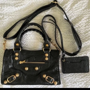 Svart city bag - Snygg svart axelväska i skinn med guldfärgade nitar, spännen och dragkedja. Liknande Balenziaga city bag💞