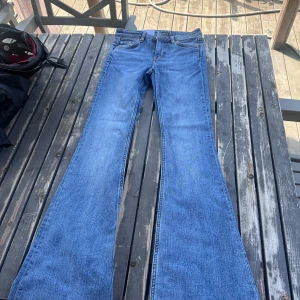 Blå bootcut jeans Monki Katsumi 25/32 - Säljer ett par blå bootcut jeans från Monki, modell Katsumi. Jeansen har klassisk femficksdesign, mid rise och snyggt utsvängda. Köptes för 499 dock passade de inte