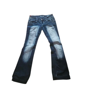 Blå bootcut jeans Crazy Age, stl 38 - Snygga blå bootcut jeans från Crazy Age med coola broderade detaljer på bakfickorna och slitningar framtill. Jeansen har låg midja och klassisk femficksdesign. Materialet är jeans i bomull med stretch för skön passform. Skriv för föer bilder osv💗