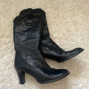 Svarta stövlar från Sixtyseven, strl 36 - Snygga svarta stövlar från Sixtyseven i äkta skinn med markerad klack och spetsig tå. Dragkedja på insidan.