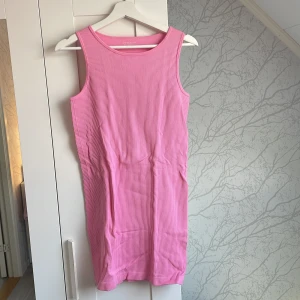 Rosa ribbad klänning från Primark - En söt rosa ribbad kortklänning från Primark. Ärmlös modell med rund halsringning och stretchigt material som sitter snyggt på kroppen. Skulle säga att den är liten i storlek så mer som en M
