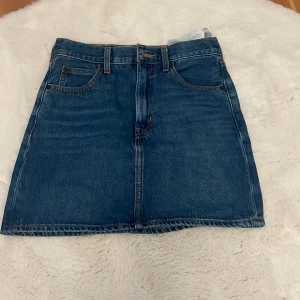 Levi's jeanskjol 70s High Micro Mini - Snygg blå jeanskjol från Levi's Premium, modell 70s High Micro Mini. Klassisk femficksdesign, bälteshällor och dragkedja framtill. 