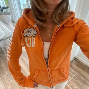 Orange Hollister zip tröja  - En zip tröja från Hollister i storlek M. Tröjan kan upplevas mindre i storlek på grund av figursydd fit. Överlag är tröjan i väldigt bra skick. E25. Jag skickar alltid inom 24h! Se fler liknande zip tröjor i min profil! 