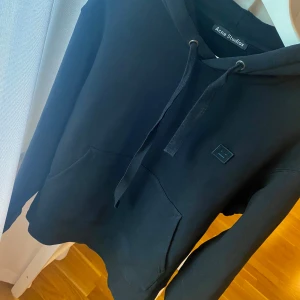 Acne Studios Ferris Hoodie Svart Storlek M - Hoodie från Acne Studios. Svart färg med face logo. Storlek Medium. Bra skick, knappt använd.