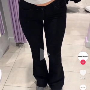 Svarta bootcut jeans från Vero Moda - Snygga svarta jeans från Vero Moda med bootcut passform. Byxorna har låg midja och klassisk femficksdesign. Perfekta för dig som gillar en stilren look med lite utsvängda ben. Materialet är stretchigt och bekvämt har ett hål vid fickan men inget man inte skulle kunna sy.