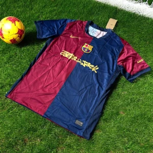 FC Barcelona Lamine Yamal matchtröja Nike - Snygg FC Barcelona matchtröja med Lamine Yamal 19 på ryggen. Tröjan är kortärmad och har klassisk halvdelad design i vinrött och marinblått med guldiga detaljer, klubbmärke och Nike-logga. Tillverkad i lätt och ventilerande polyester, perfekt för fotbollsplanen.