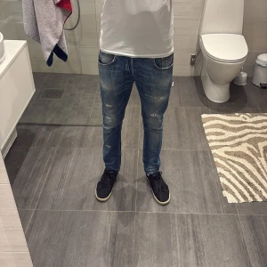 Dondup jeans - Dondup Jeans i storlek 30, passar större. Ljusblå disign med fabriks hål. Väldigt bra skick och en väldigt känd modell, litet hål vid högra fram knät som man kan fixa genom att sy en lapp under ifall man vill men personligen tycker jag det är snyggt så, går knappt att se hålet, bild 1. Sedan har taggen på insidan spruckit lite men inget som känns eller märks av, kan skicka bild vid förfrågan.
