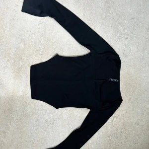 Svart ribbad långärmad topp - Snygg svart långärmad topp med ribbad struktur och fyrkantig urringning. Modellen är tight med stretch , perfekt att styla med höga jeans eller kjol. Tidlös och enkel design som passar till många olika looks.