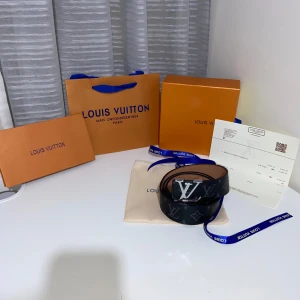 Svart bälte med en silver logga - Säljer ett svart bälte med en silver logga!! Dm vid intresse!! Kan gå ner i pris!!