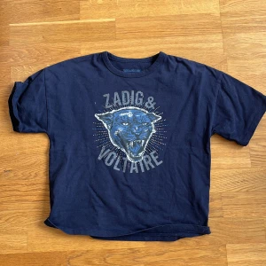 Mörkblå Zadig & Voltaire t-shirt - Cool mörkblå t-shirt från Zadig & Voltaire med tryck av en panter och logga på bröstet. Klassisk rund hals och korta ärmar. Skön passform och tillverkad i mjuk bomull, perfekt för en avslappnad streetstyle.