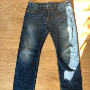 Diesel jeans slitningar - Dessa är ett par sjukt snygga diesel jeans med slitningar och dom passar med allt! Bara att skriva om funderingar! Cond:8/10, använda men riktigt bra skick!