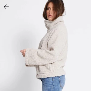 Beige teddyjacka med dragkedja - Mysig beige teddyjacka med hög krage och hel dragkedja framtill. Jackan har två stora fickor och en loose passform som ger en chill vibe. Perfekt för kalla dagar när du vill vara både varm och snygg. Nypris 250😇