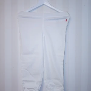 Collection by Jackpots vita Capri byxor, XS - Snygga vita Capri byxor med resår i midjan och rynkdetaljer nedtill. Byxorna är i modellen slim fit. Kan skickas med extra pris via post.
