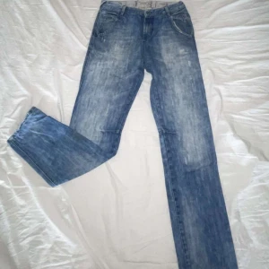 Blå jeans från Scotch Shrunk - Snygga blå jeans från Scotch Shrunk med klassisk femficksdesign och coolt fiskemärke på myntfickan. Jeansen har ett unikt mönstrat innerfoder i midjan och raka ben. Perfekta för dig som gillar en avslappnad men stilren look.