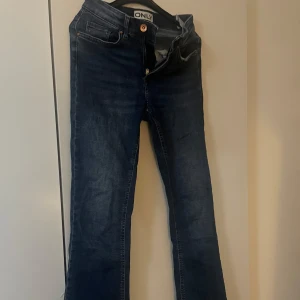 Mörkblå bootcut jeans från ONLY - Snygga mörkblå jeans från ONLY med bootcut passform. Klassisk femficksmodell med dragkedja och knapp framtill. Jeansen har en lätt tvättad look och är tillverkade i stretchigt denimtyg för extra komfort.