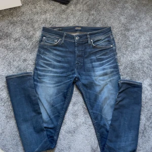 Jack & Jones slim straight jeans blå - Snygga blå jeans från Jack & Jones med slim straight passform. ljusa slitningar framtill och kontrastsömmar. Tillverkade i mjukt denimtyg med läderpatch bak i midjan. Storlek 29-32 (Priset är inte spikat!!) så kom men bus eller frågor MVH Lex😁
