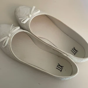 Vita ballerinaskor med spets och rosett - Säljer dessa vit ballerinaskor från XIT då dom inte passar längre tyvärr, dom är endast använda under min bal och dom är i ett mycket bra skick! Hör gärna av dig om du undrar något! 💞💞 dom är i storlek 38!