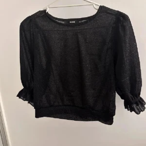 Svart glittrig blus från Bik Bok - Supersnygg svart glittrig blus från Bik Bok endast använd 1 gång. Kontakta för fler bilder.