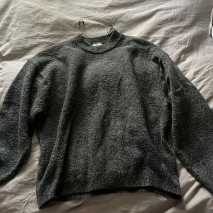 Mörkgrå stickad tröja med rund hals från h&m  - Mysig mörkgrå stickad tröja med rund halsringning och ribbade muddar vid ärmslut och nederkant. Perfekt för lager-på-lager och chill dagar. Enkel och stilren design som funkar till det mesta. Andvänd några få antal gånger.