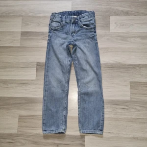 Ljusblå slim jeans från H&M  - Snygga ljusblå jeans från H&M i slim fit-modell med regular midja. Klassisk femficksdesign, justerbar midja med knappresår och dragkedja. Perfekta för dig som gillar en enkel och stilren look.