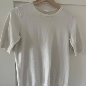 Vit kortärmad tröja - En stilren vit stickad tröja med rund halsringning och korta ärmar. Perfekt för dig som gillar en enkel och clean look. Tröjan har en mjuk känsla och passar bra till både jeans och kjol. Från HM