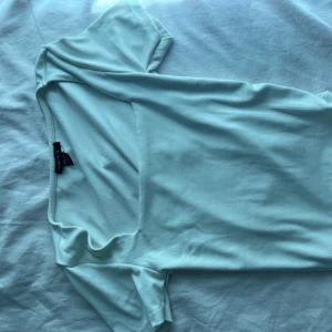 Ljusblå topp från Amisu XS - Säljer en ljusblå topp från Amisu i storlek XS. Toppen har korta ärmar och en snygg fyrkantig ringning. Tillverkad i mjukt och stretchigt material som sitter skönt på kroppen. Perfekt för dig som gillar stilrena och enkla plagg.