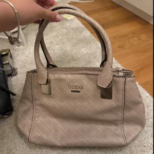 Beige handväska från Guess - Säljer en snygg beige handväska från Guess. köp flera plagg i bundles för ett billigare pris!❤️