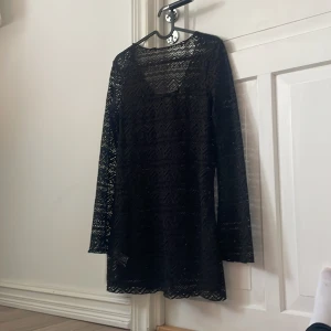 Svart strand klänning med rosett i bak från HM - Svart strand klänning, med rosett i bak även med volang armar. Aldrig använd.